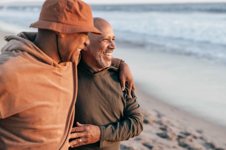 Photo of two men embracing each other on the beach