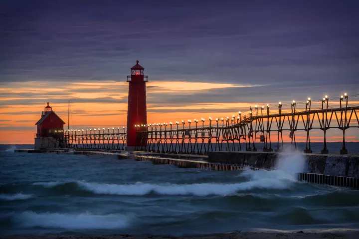 Photo of a pier and lighthouse in sunset