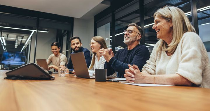 Photo of people sitting around a conference table talking