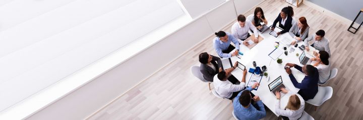 Photo of a group of people sitting around a table talking